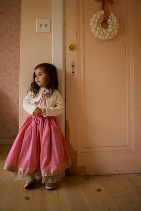 Child in front of pink door